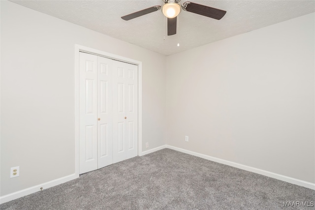 unfurnished bedroom with carpet, a textured ceiling, a closet, and ceiling fan