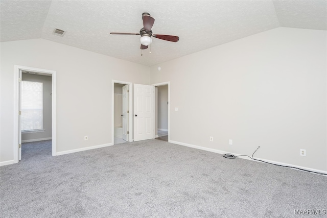 unfurnished bedroom with ceiling fan, a textured ceiling, vaulted ceiling, and carpet floors