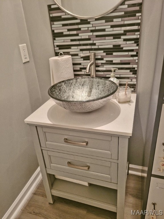 bathroom featuring vanity, wood-type flooring, and tasteful backsplash