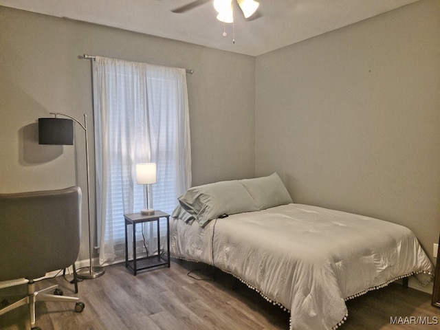 bedroom featuring hardwood / wood-style floors, multiple windows, and ceiling fan