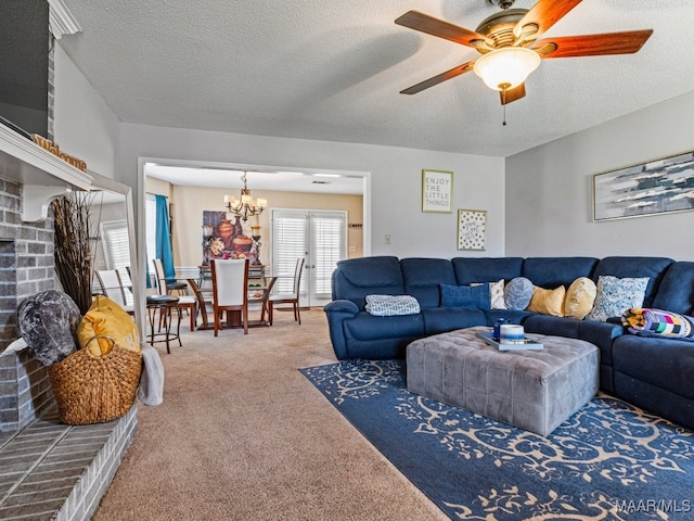 carpeted living room featuring ceiling fan with notable chandelier, a textured ceiling, and a brick fireplace