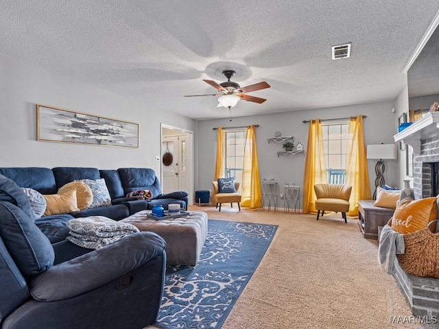 carpeted living room featuring ceiling fan, a fireplace, and a textured ceiling