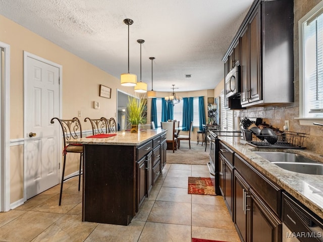 kitchen with plenty of natural light, a kitchen island, a breakfast bar area, and appliances with stainless steel finishes