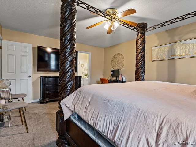 carpeted bedroom featuring ceiling fan, ensuite bathroom, and a textured ceiling