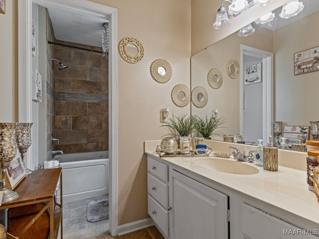 bathroom with tiled shower / bath combo, a textured ceiling, and vanity