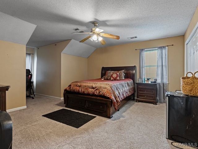 carpeted bedroom with lofted ceiling, ceiling fan, and a textured ceiling