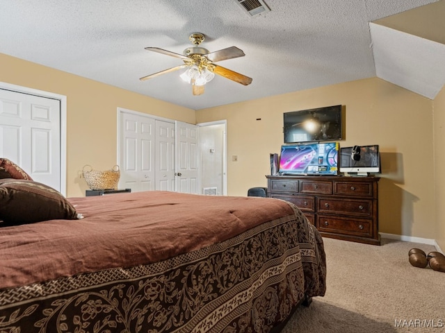 carpeted bedroom featuring ceiling fan, lofted ceiling, and a textured ceiling