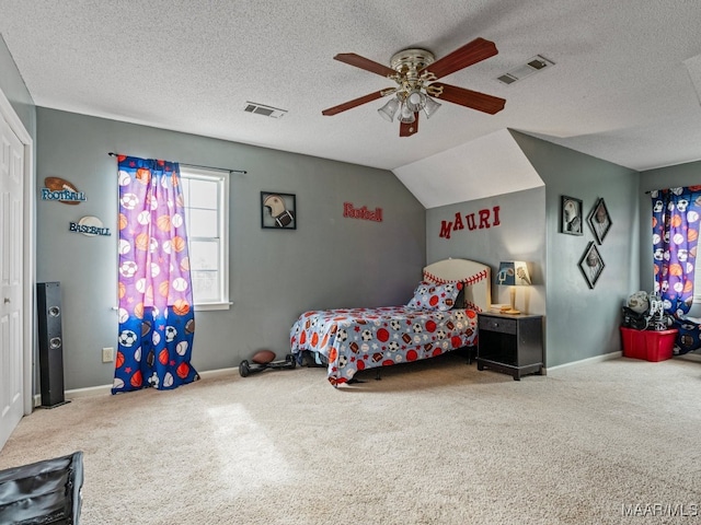 carpeted bedroom with a textured ceiling, vaulted ceiling, and ceiling fan