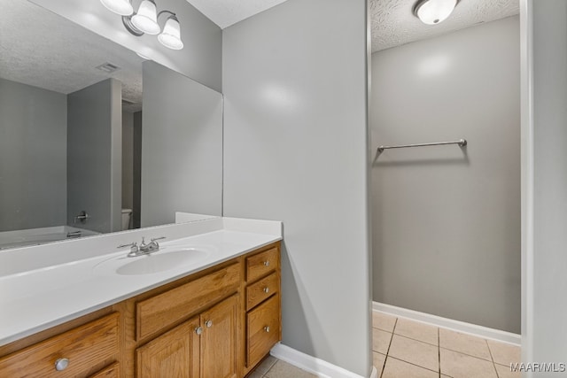 bathroom with vanity, a textured ceiling, toilet, and tile patterned floors