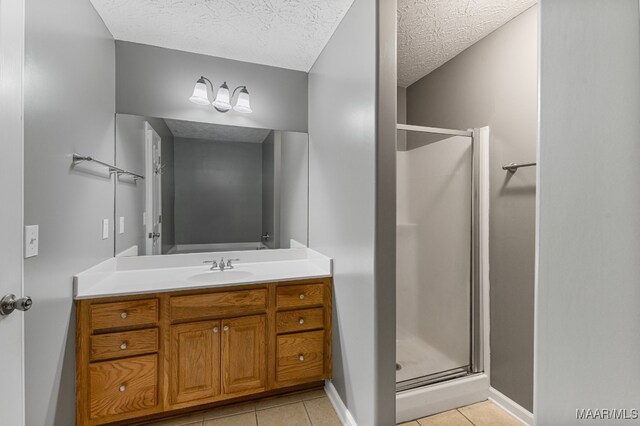 bathroom with vanity, a textured ceiling, walk in shower, and tile patterned flooring