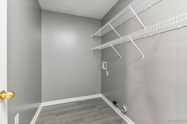 washroom featuring hookup for a washing machine, a textured ceiling, gas dryer hookup, and hardwood / wood-style floors