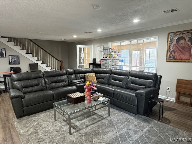 living room featuring a textured ceiling, crown molding, and wood-type flooring