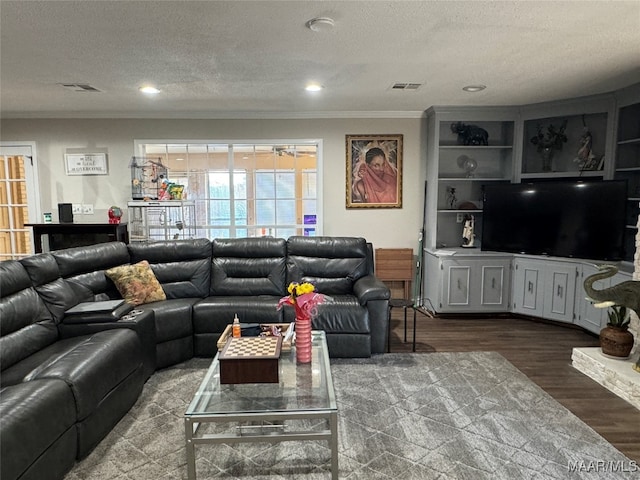 living room with ornamental molding, a textured ceiling, and dark hardwood / wood-style flooring