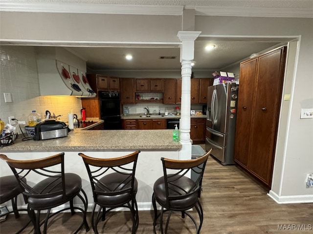 kitchen featuring kitchen peninsula, stainless steel fridge, backsplash, and dark hardwood / wood-style floors