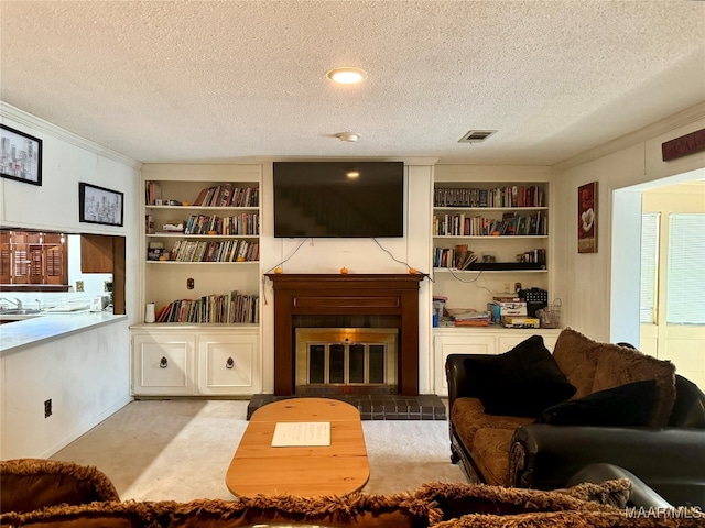 carpeted living room featuring a textured ceiling, ornamental molding, and built in shelves