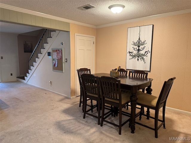 dining space featuring light carpet, a textured ceiling, and ornamental molding