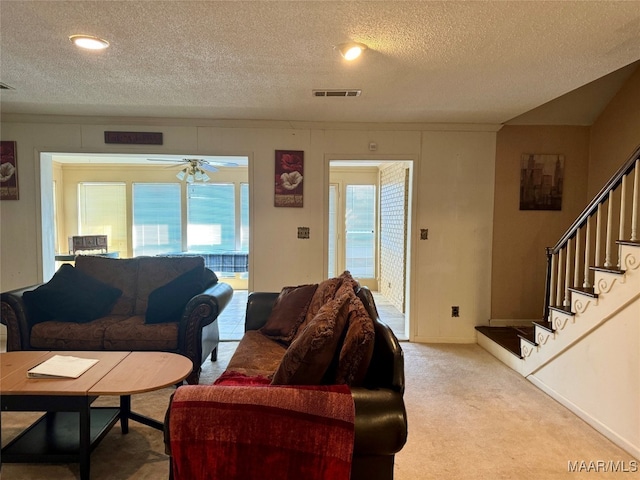 carpeted living room with ceiling fan, a textured ceiling, and plenty of natural light