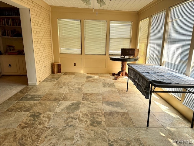 sunroom featuring ceiling fan and wood ceiling