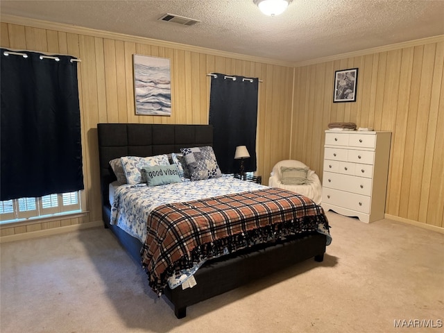 bedroom featuring a textured ceiling, carpet floors, and ornamental molding