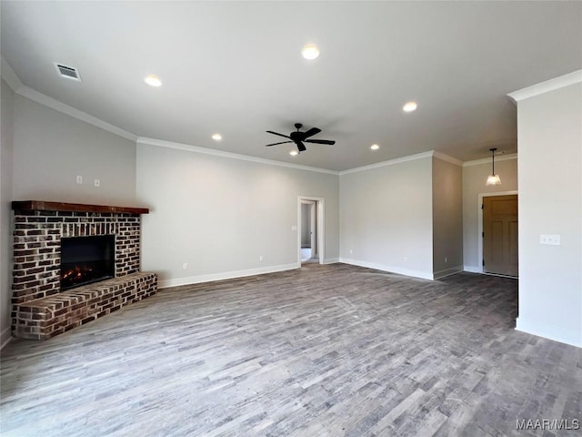 unfurnished living room featuring a fireplace, ceiling fan, ornamental molding, and hardwood / wood-style flooring