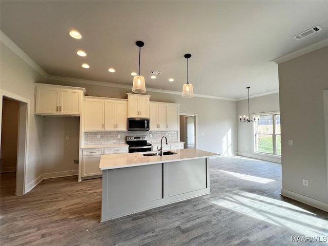 kitchen featuring white cabinets, stainless steel appliances, a center island with sink, and sink