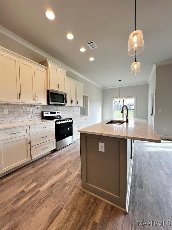 kitchen featuring stainless steel appliances, white cabinetry, sink, and a kitchen island with sink