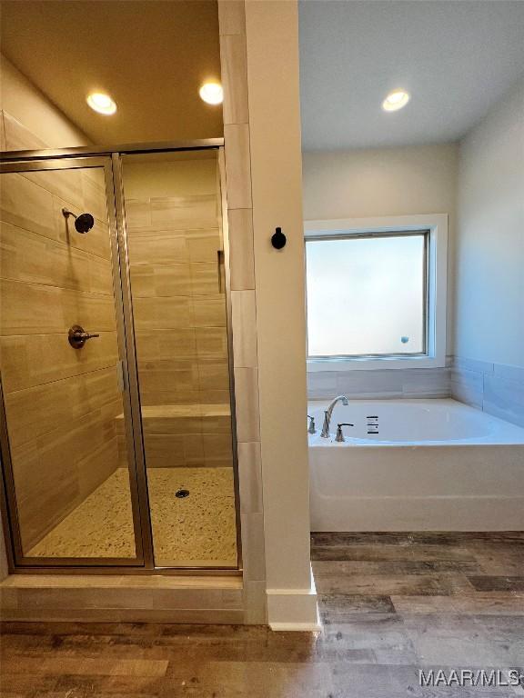 bathroom with plus walk in shower and hardwood / wood-style floors