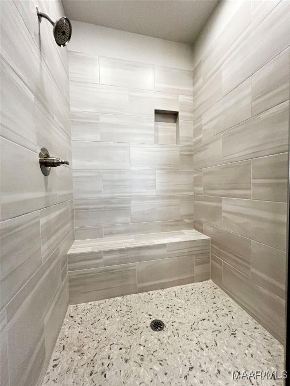 full bath featuring tiled shower