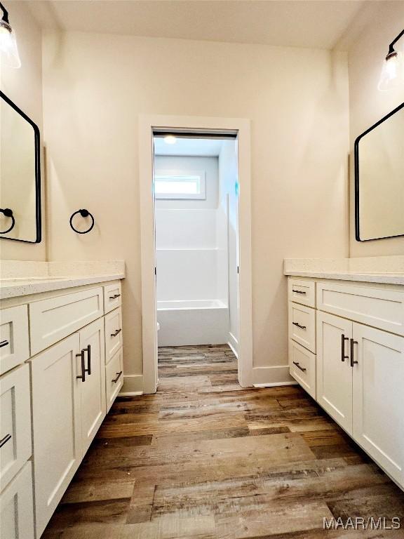 bathroom featuring baseboards, wood finished floors, and vanity