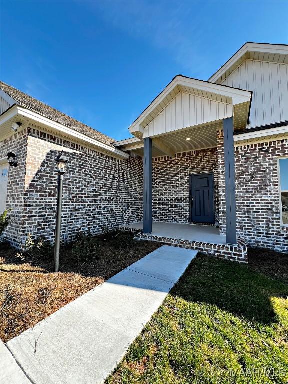 property entrance with brick siding and board and batten siding