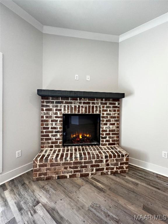 details with a fireplace, crown molding, baseboards, and wood finished floors