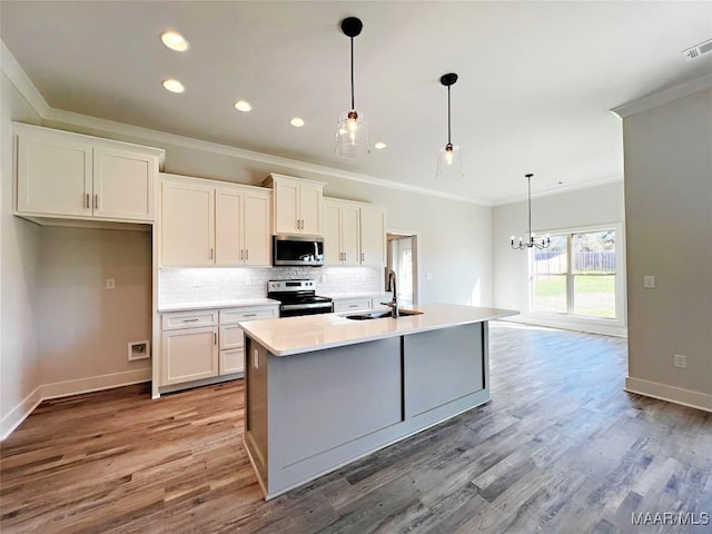 kitchen with a sink, stainless steel appliances, light countertops, and white cabinetry