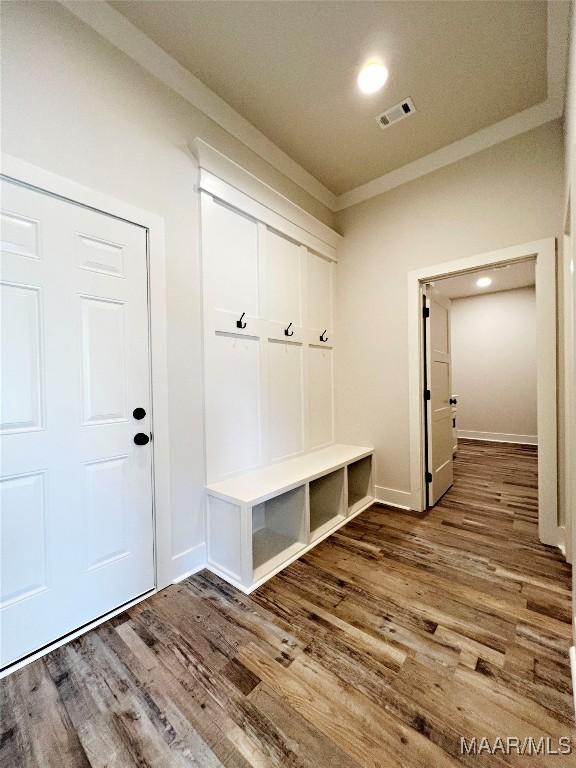 mudroom featuring baseboards, visible vents, wood finished floors, and ornamental molding