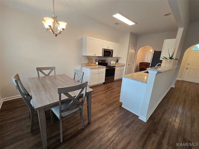 kitchen with dark hardwood / wood-style floors, hanging light fixtures, kitchen peninsula, black range with electric cooktop, and white cabinets