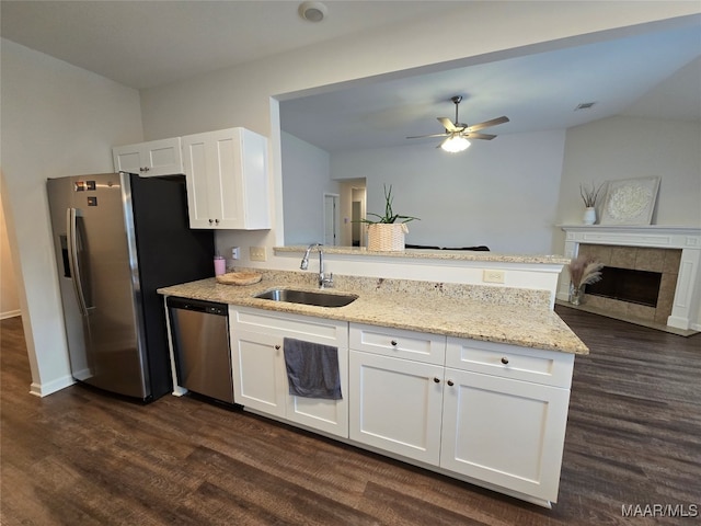 kitchen with dark wood-type flooring, sink, light stone countertops, white cabinetry, and appliances with stainless steel finishes