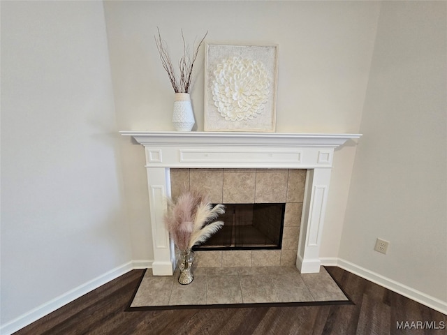 details with hardwood / wood-style floors and a tile fireplace