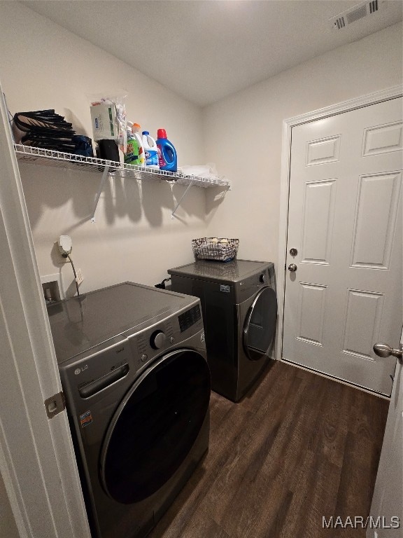 laundry room with independent washer and dryer and dark hardwood / wood-style flooring