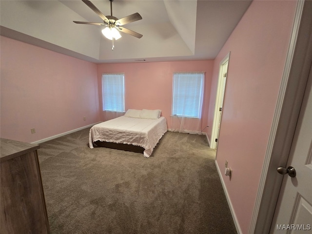 unfurnished bedroom with a raised ceiling, carpet flooring, and ceiling fan