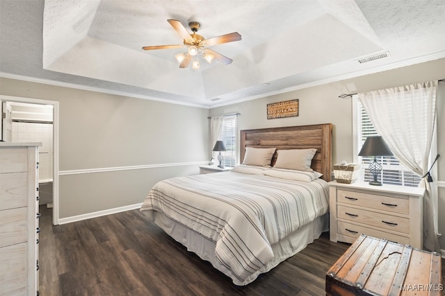 bedroom with dark wood-type flooring, ceiling fan, and a raised ceiling