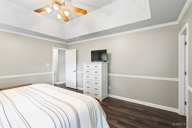 bedroom with a textured ceiling, a tray ceiling, ceiling fan, dark wood-type flooring, and crown molding