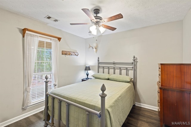 bedroom featuring dark hardwood / wood-style floors, a textured ceiling, and ceiling fan