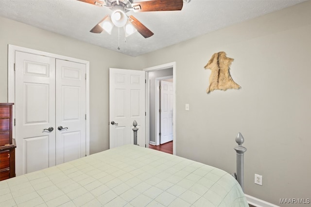 bedroom with a closet, ceiling fan, and a textured ceiling