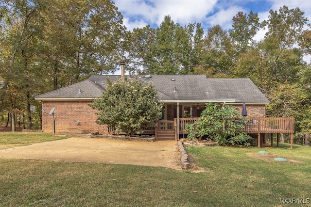 rear view of house featuring a deck and a lawn