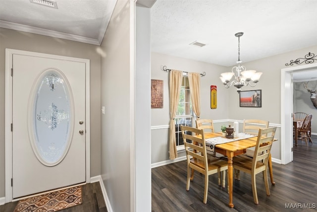 foyer entrance with ornamental molding, dark wood-type flooring, and a textured ceiling