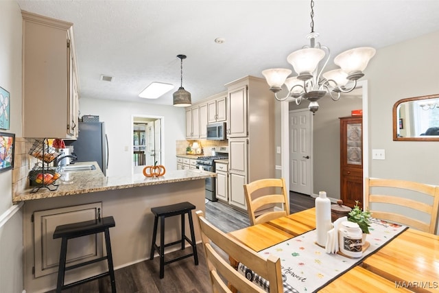 dining space with dark hardwood / wood-style floors, a chandelier, sink, and a textured ceiling