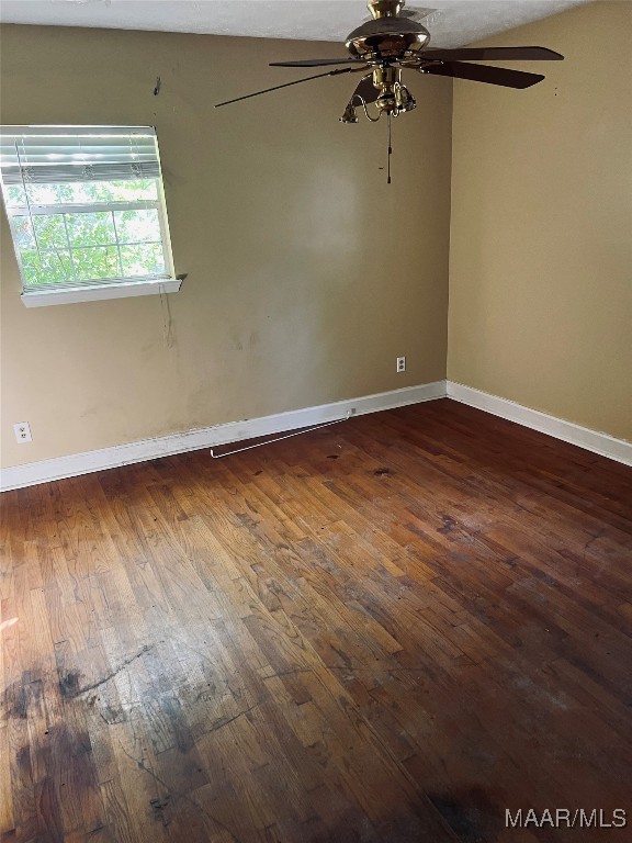 spare room with dark hardwood / wood-style floors and ceiling fan