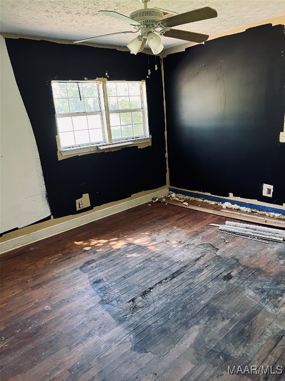 spare room with ceiling fan, wood-type flooring, and a textured ceiling