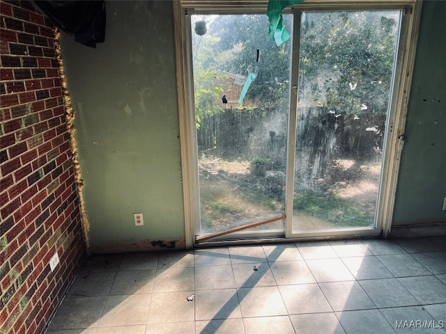 entryway featuring brick wall and light tile patterned floors