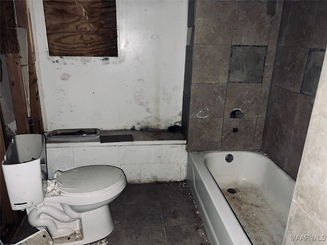 bathroom featuring toilet, a bathing tub, and tile patterned flooring