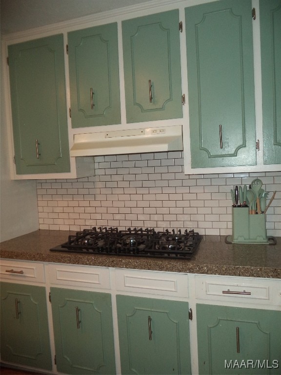 kitchen with tasteful backsplash, green cabinets, and gas stovetop